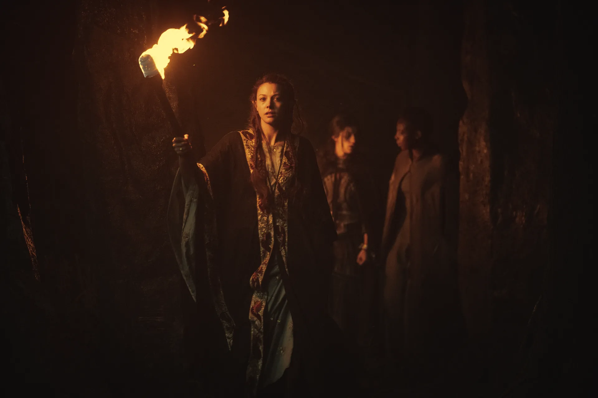 Två alver leder Yennefer av Vengerberg genom en grotta i fackelljus i Netflix The Witcher.